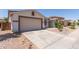 View of the home's two-car garage and neutral color palette with minimal desert landscaping at 7205 W Ellis St, Laveen, AZ 85339
