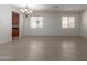 Spacious living room with wood-look floors, natural light, and an elegant chandelier at 7205 W Ellis St, Laveen, AZ 85339