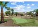 Manicured backyard featuring a putting green, lush greenery, and a relaxing outdoor entertainment space at 7205 W Fallen Leaf Ln, Peoria, AZ 85383