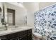Bright bathroom featuring a vanity with a white countertop, a toilet, and a shower with a butterfly curtain at 7205 W Fallen Leaf Ln, Peoria, AZ 85383