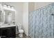 Bathroom featuring a single vanity, a toilet, and a tub with a decorative shower curtain at 7205 W Fallen Leaf Ln, Peoria, AZ 85383