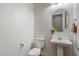 Powder room featuring a pedestal sink, round mirror, and a toilet at 7205 W Fallen Leaf Ln, Peoria, AZ 85383