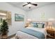Well-lit bedroom with a queen bed, neutral tones, and soft blue decorative pillows and blanket at 7205 W Fallen Leaf Ln, Peoria, AZ 85383