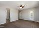 A well-lit bedroom featuring neutral-colored carpet, a ceiling fan, and two entryways at 7205 W Fallen Leaf Ln, Peoria, AZ 85383