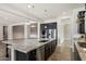 Kitchen featuring stainless steel appliances, dark cabinets and a large granite island at 7205 W Fallen Leaf Ln, Peoria, AZ 85383