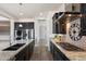 Modern kitchen with dark cabinets, stainless steel appliances, and long granite countertop at 7205 W Fallen Leaf Ln, Peoria, AZ 85383