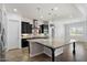 Modern kitchen features black cabinets, stainless steel appliances, granite countertops, and large island at 7205 W Fallen Leaf Ln, Peoria, AZ 85383