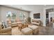 Spacious living room with neutral furniture, wood accents, and natural light from large windows at 7205 W Fallen Leaf Ln, Peoria, AZ 85383