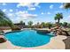 Sparkling pool with rock waterfall, fountains, and lush landscaping for serene outdoor enjoyment at 7205 W Fallen Leaf Ln, Peoria, AZ 85383