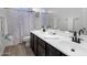 Bathroom featuring a shower, toilet and a dual sink vanity with white countertops and dark cabinetry at 7616 S Sorrell Ln, Gilbert, AZ 85298