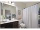 Well-lit bathroom featuring a dark vanity, shower with curtain and decor at 7616 S Sorrell Ln, Gilbert, AZ 85298