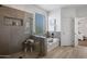 Bathroom featuring a separate shower and soaking tub with neutral tile and a window at 7616 S Sorrell Ln, Gilbert, AZ 85298