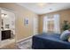 Cozy bedroom featuring a blue bed, ensuite bathroom, and ample natural light at 7616 S Sorrell Ln, Gilbert, AZ 85298