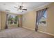 Spacious bedroom with carpet, ceiling fan and natural light from large windows at 7616 S Sorrell Ln, Gilbert, AZ 85298