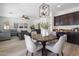 Open-concept dining area flowing into the living room and kitchen, featuring a modern light fixture and comfortable seating at 7616 S Sorrell Ln, Gilbert, AZ 85298