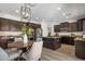 Spacious kitchen with dark wood cabinets, granite countertops, stainless steel appliances, and a dining area at 7616 S Sorrell Ln, Gilbert, AZ 85298