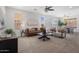 Bright and airy living room featuring a leather sofa and multiple windows at 7616 S Sorrell Ln, Gilbert, AZ 85298