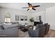 Bright living room featuring comfortable seating, stylish decor, a modern ceiling fan, and wood flooring at 7616 S Sorrell Ln, Gilbert, AZ 85298