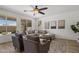Bright and airy living room with multiple windows, comfortable seating, modern ceiling fan, and stylish decor at 7616 S Sorrell Ln, Gilbert, AZ 85298