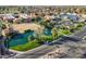 Aerial view of community featuring a pond with fountain, sports facilities, grassy areas, and palm tree landscaping at 906 Leisure World --, Mesa, AZ 85206