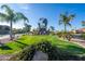 View of a community entrance featuring a decorative globe, lush greenery, and manicured landscaping at 906 Leisure World --, Mesa, AZ 85206