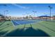 Well-maintained blue and green tennis court with covered seating, lights, and perimeter fencing at 906 Leisure World --, Mesa, AZ 85206