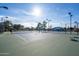 View of well-maintained tennis courts with lights, seating, and perimeter fencing in a sunny neighborhood at 906 Leisure World --, Mesa, AZ 85206