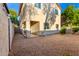 Backyard with gravel, covered patio, and back exterior of tan two-story home at 10225 W Camelback Rd # 33, Phoenix, AZ 85037