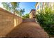 Gravel backyard surrounded by block fence and foliage, next to tan exterior of home at 10225 W Camelback Rd # 33, Phoenix, AZ 85037
