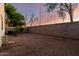 The backyard features gravel landscaping, partial privacy fencing, and dusk lighting at 10225 W Camelback Rd # 33, Phoenix, AZ 85037