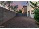 Gravel backyard surrounded by block fence, next to exterior of home at 10225 W Camelback Rd # 33, Phoenix, AZ 85037