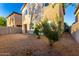 Backyard area, featuring gravel and the tan back exterior of the two-story home at 10225 W Camelback Rd # 33, Phoenix, AZ 85037