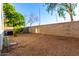 Backyard area with rock and low-water landscaping, next to tan exterior of home at 10225 W Camelback Rd # 33, Phoenix, AZ 85037