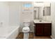 Bright bathroom with a shower-tub combo, tile flooring, and a dark vanity with a single sink at 10225 W Camelback Rd # 33, Phoenix, AZ 85037