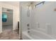 Well-lit bathtub and shower combination with white tiled walls and tile flooring at 10225 W Camelback Rd # 33, Phoenix, AZ 85037