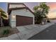This is an exterior shot of the home with a two-car garage and desert landscaping at 10225 W Camelback Rd # 33, Phoenix, AZ 85037