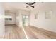 Bright and airy living room featuring light-colored walls, wood floors, ceiling fan and sliding glass door at 10225 W Camelback Rd # 33, Phoenix, AZ 85037