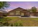 Large backyard featuring well maintained lawn with extended covered patio, and stucco wall at 10318 E Plata Ave, Mesa, AZ 85212