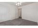 An empty bedroom featuring neutral carpet, ceiling fan and a closet with sliding doors at 10318 E Plata Ave, Mesa, AZ 85212