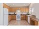 Well-lit kitchen features tile floors, wood cabinetry, and white appliances at 10318 E Plata Ave, Mesa, AZ 85212
