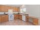 Bright kitchen with tiled floors, wooden cabinets, modern white oven and dishwasher at 10318 E Plata Ave, Mesa, AZ 85212