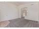 Open-concept living room with neutral carpet and an archway to the kitchen at 10318 E Plata Ave, Mesa, AZ 85212