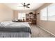 Bedroom with carpet and queen bed in neutral colors with ceiling fan, desk, and decorations at 1263 W Del Rio St, Chandler, AZ 85224