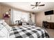 Bright bedroom with a ceiling fan, comfy chair, and a doorway to the outside at 1263 W Del Rio St, Chandler, AZ 85224