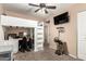 Bedroom with a full workstation and shelving in the unit, along with a ceiling fan and wall mounted TV at 1263 W Del Rio St, Chandler, AZ 85224