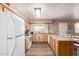 Functional kitchen with wooden cabinets, tile flooring, and essential appliances at 1263 W Del Rio St, Chandler, AZ 85224