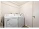Functional laundry room with white washer and dryer units, white walls and door, and overhead rack at 1263 W Del Rio St, Chandler, AZ 85224