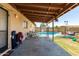 Covered patio with outdoor furniture, bicycles, and a view of the sparkling backyard swimming pool at 1263 W Del Rio St, Chandler, AZ 85224