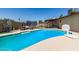 Pool area with diving board, outdoor seating, and a trampoline, set against a clear blue sky at 1263 W Del Rio St, Chandler, AZ 85224