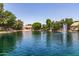 Beautiful lake view homes featuring lush landscaping, calm waters, and a tranquil fountain on a clear and sunny day at 1263 W Del Rio St, Chandler, AZ 85224